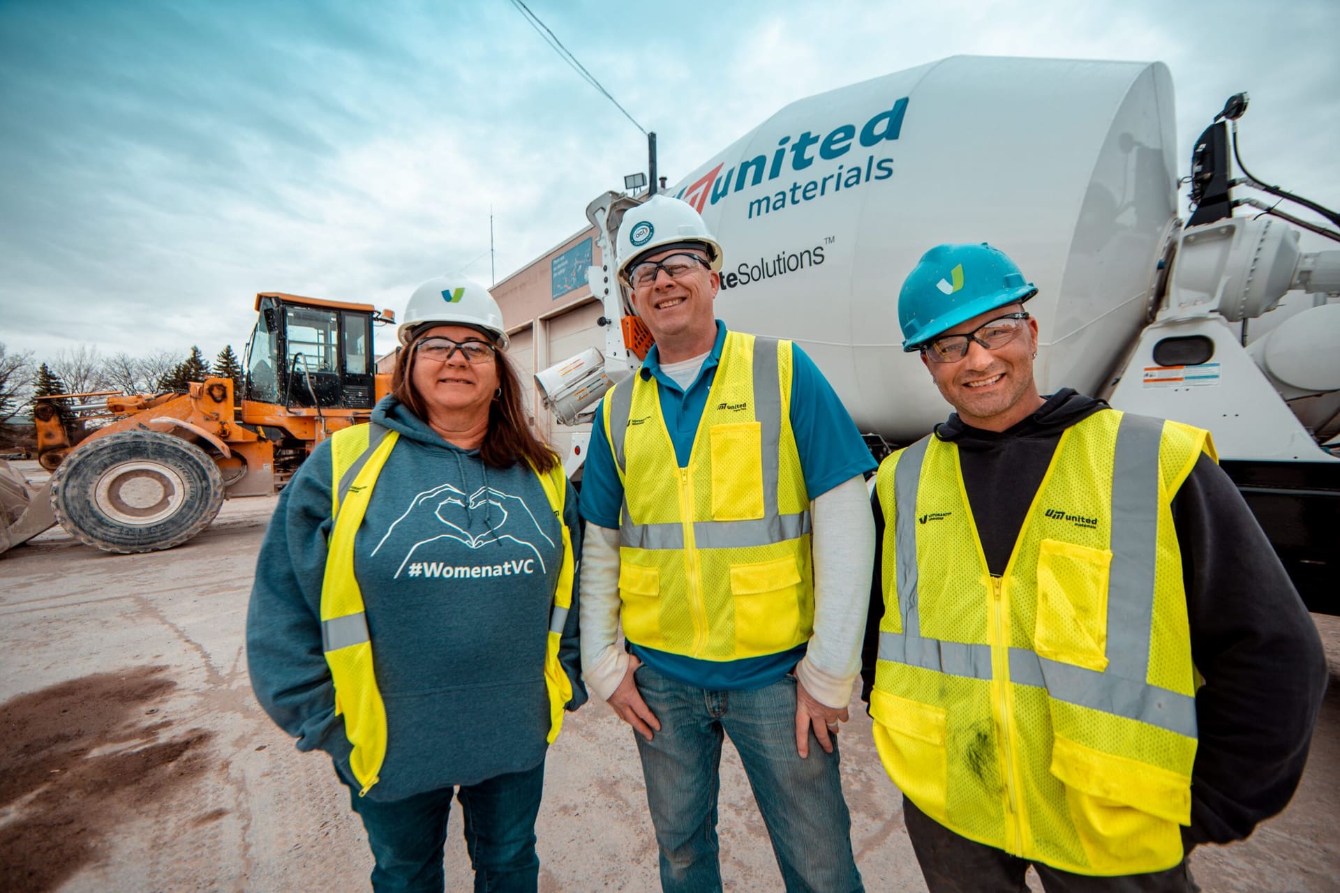 DiamondDrive - three United Materials team members in front of a mixer truck and loader