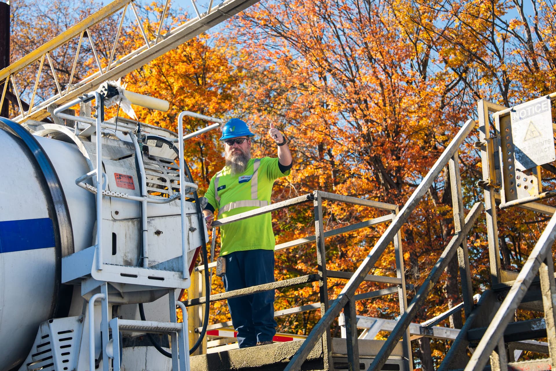 EasyFlow - United Materials worker waving from a platform beside a mixer truck at the plant