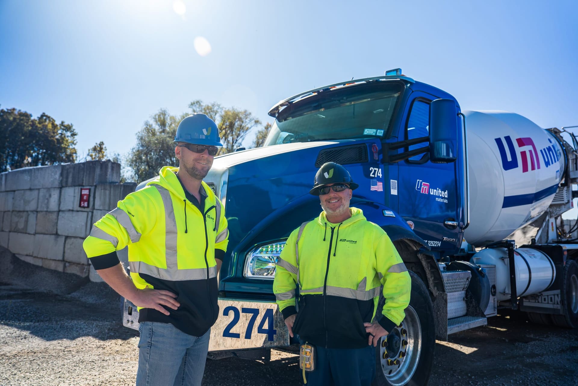 Get-Set - two United Materials workers posing beside ready-mix truck 274 at the plant